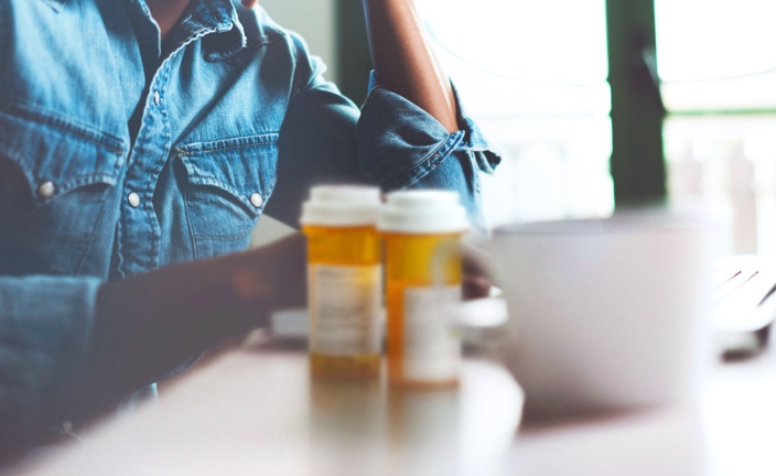 Man with coffee and pill bottles