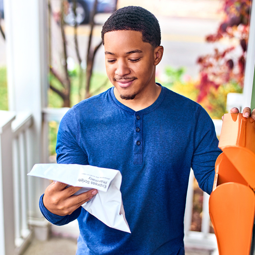 man looking at pharmacy benefit statement he just received in the mail