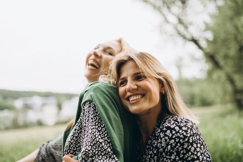 Two women embrace and smile