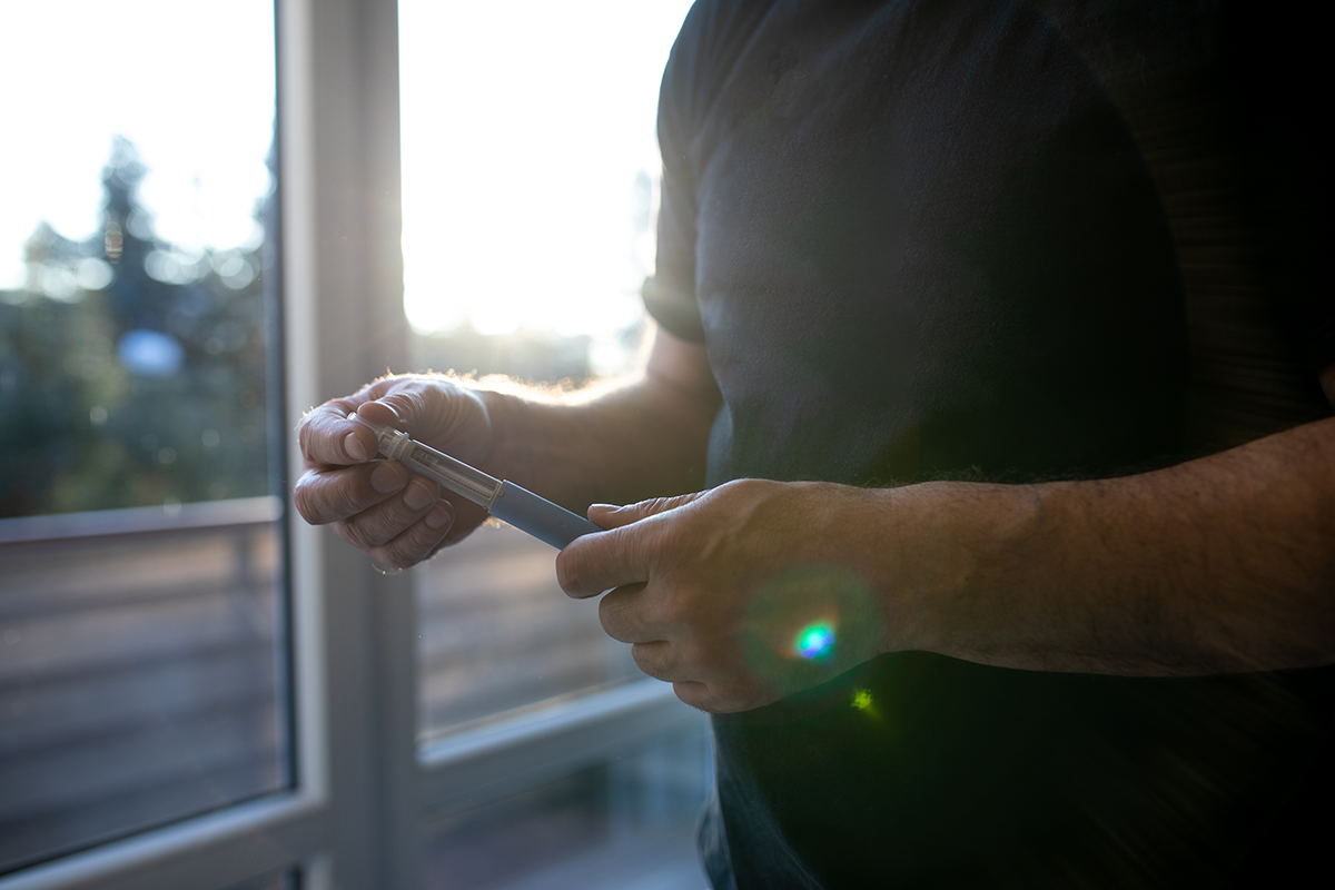 Adult preparing a GLP-1 medication injection, such as semaglutide, for weight loss or type 2 diabetes management