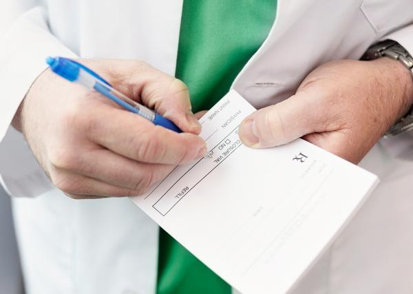 A doctor writes a prescription for a patient.