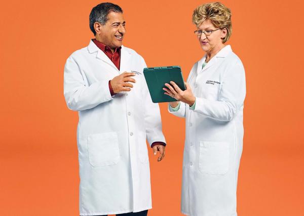 Two pharmacists with Express Scripts® Pharmacy look over a patient’s medication list on their tablet.Two pharmacists with Express Scripts® Pharmacy look over a patient’s medication list on their tablet.