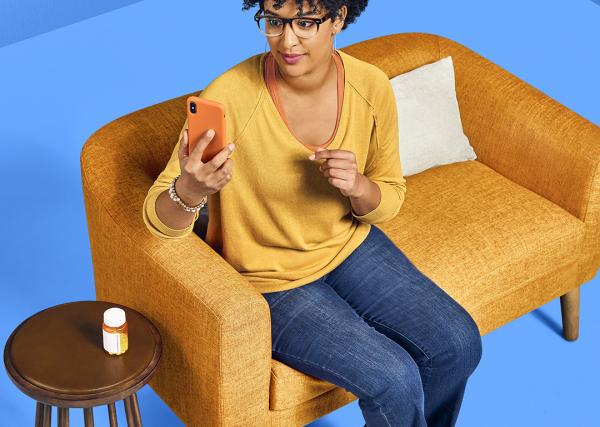 A woman checks her medications on her mobile phone using the Express Scripts® Pharmacy app.