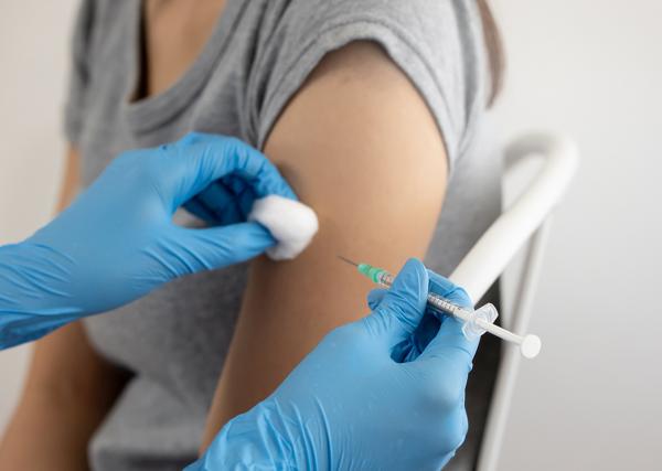 The arm of a woman receiving a vaccination is shown.