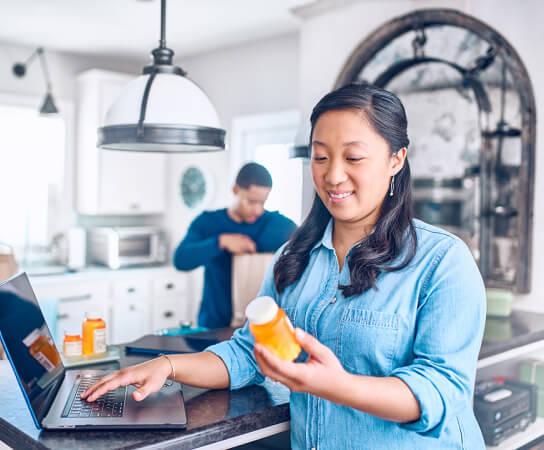 Woman holding and reading pill bottle