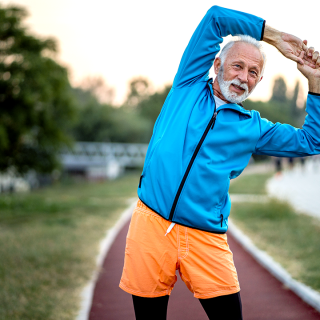 Older man stretching outdoors.