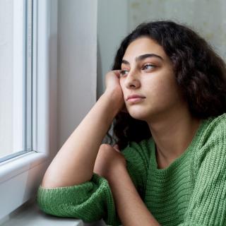 A young woman gazes out a window 
