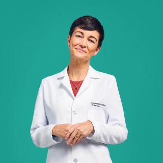 A pharmacist smiles in her Express Scripts® Pharmacy lab coat.